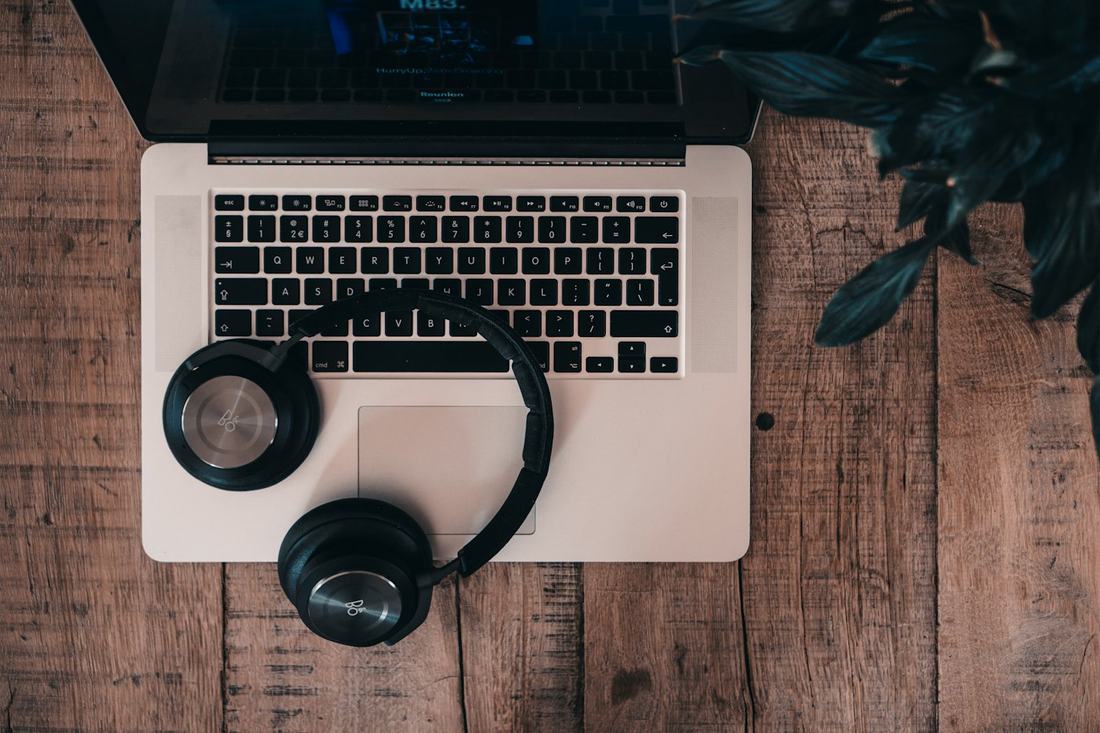 Laptop met headset op een houten bureau