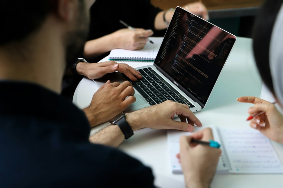 Deelnemers met laptops aan tafel tijdens een training